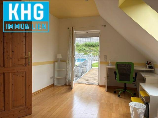 Helles Arbeitszimmer mit Holzboden und direktem Zugang zum Poolbereich im Freien.