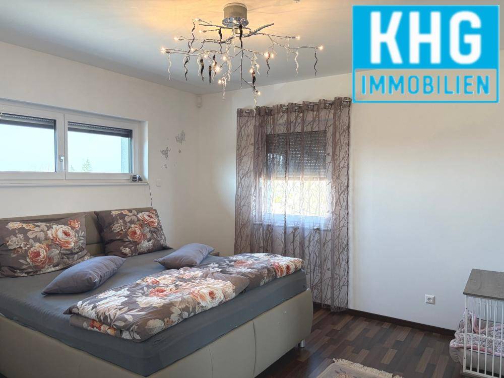 Gemütliches Schlafzimmer mit Doppelbett, Holzboden und Fenster mit Blick nach draußen.