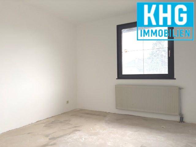 Unmöblierter Raum mit Fenster und Heizkörper, bietet viel Potenzial für individuelle Nutzung.