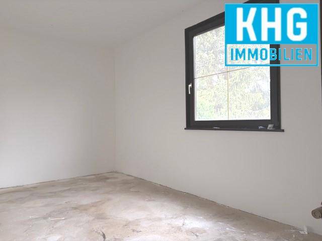 Helles, unmöbliertes Zimmer mit großem Fenster, bereit für neue Einrichtungsideen.
