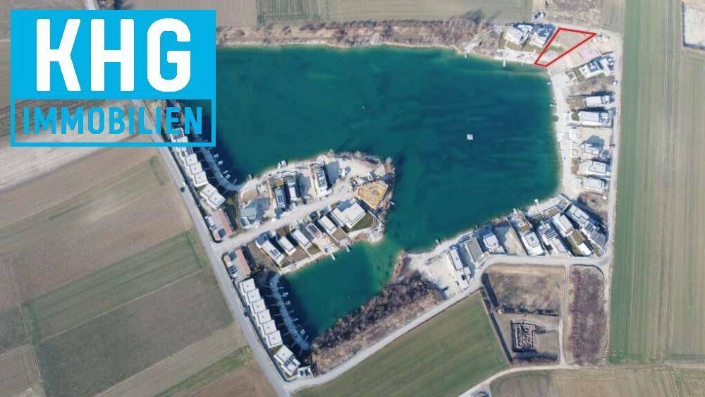 Weitläufige Luftaufnahme einer Wohnsiedlung am See mit zahlreichen Grundstücken und Häusern.