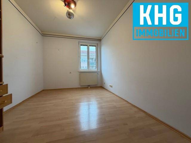 Helles Zimmer mit Holzboden und einem Fenster, ideal als Schlaf- oder Arbeitszimmer.