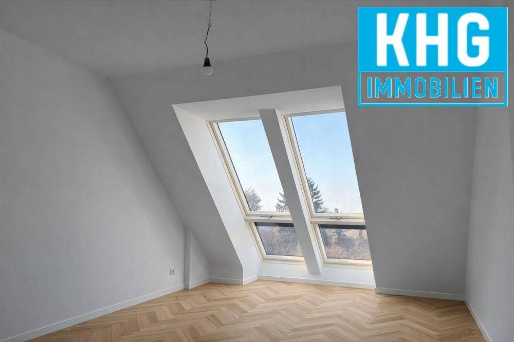 Helles Schlafzimmer im Dachgeschoss mit schrägen Wänden, großen Dachfenstern und Fischgrätparkett.