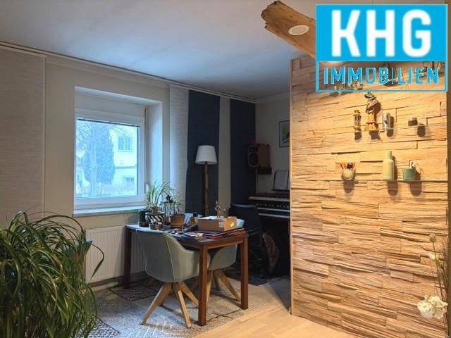 Ruhiges Arbeitszimmer mit Holzwandverkleidung, Schreibtisch und Fenster.