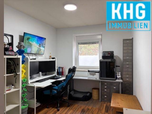 Funktionales Arbeitszimmer mit Schreibtisch, Computer und Stauraum, gut beleuchtet.