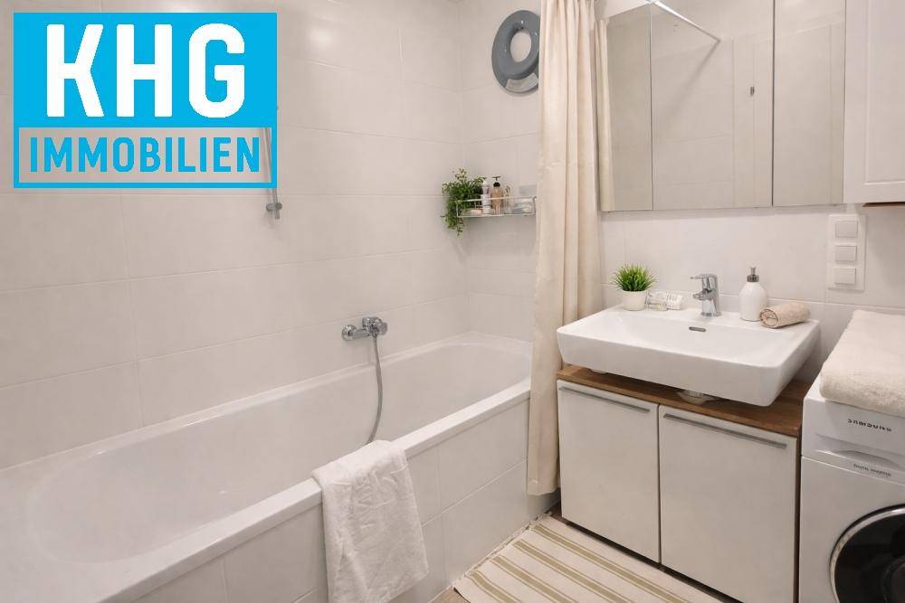 Modernes Badezimmer mit Badewanne, Waschbecken und Waschmaschine.