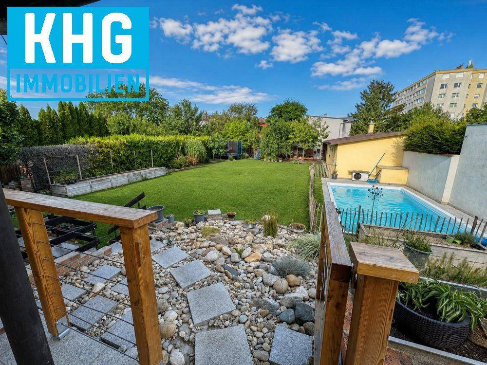 Blick auf den weitläufigen Garten mit Steingarten, Rasenfläche und einem erfrischenden Swimmingpool.