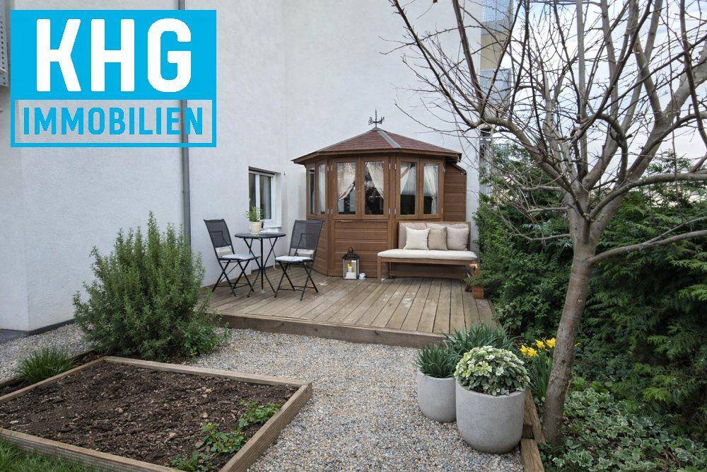 Gemütlicher Gartenbereich mit Holzterrasse, Gartenlaube und Hochbeet.