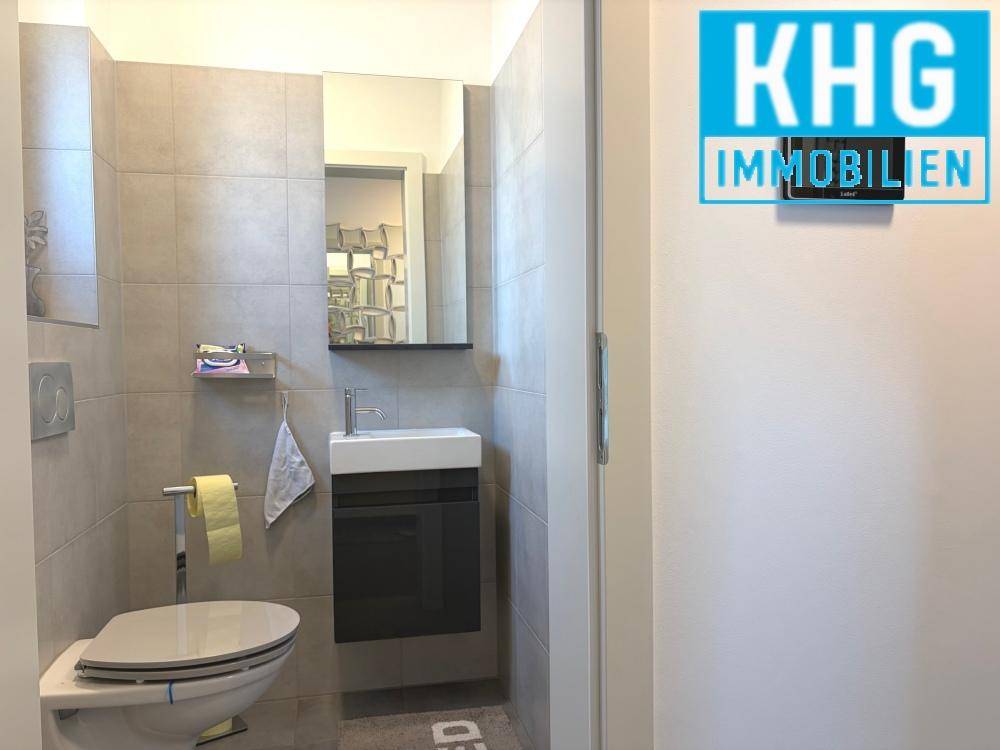Modernes Gäste-WC mit kleinem Waschbecken und Wand-WC.