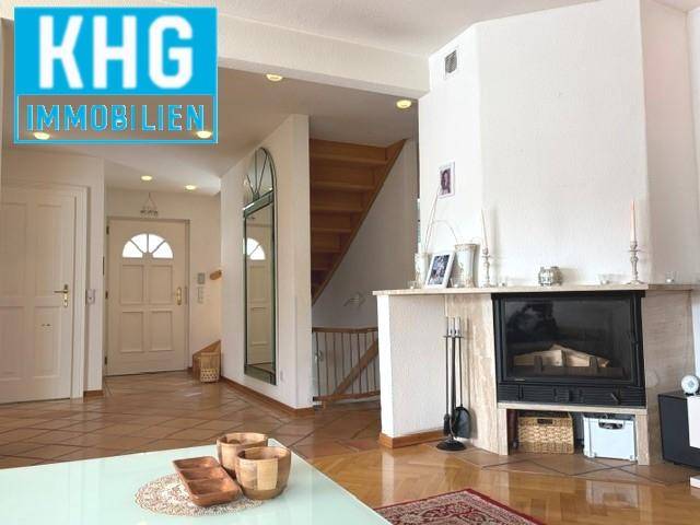 Eingangsbereich mit Kamin und Holztreppe, der zu den oberen Etagen führt.