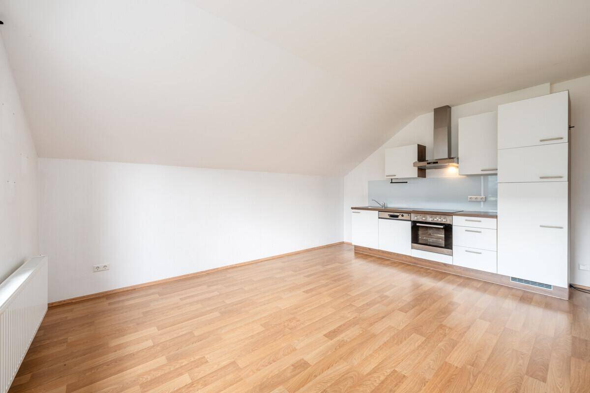 Helle Dachgeschosswohnung mit moderner Küchenzeile und Laminatboden.