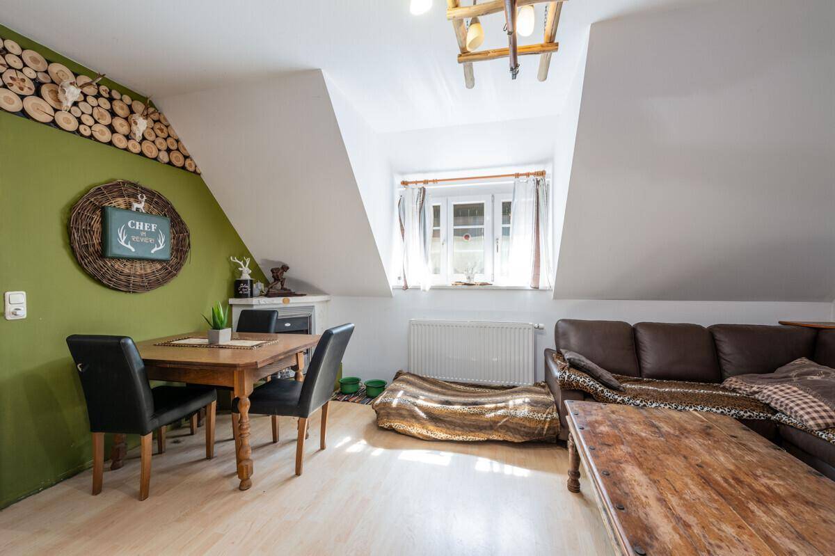 Kombinierter Wohn- und Essbereich mit Sofa, Esstisch und rustikaler Holzdekoration an der Wand.
