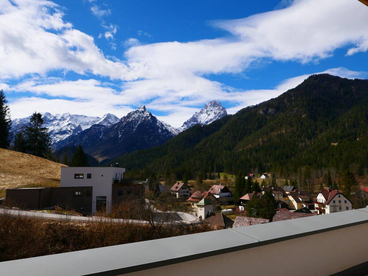 Panoramablick auf schneebedeckte Berge und ein malerisches Dorf in den Alpen.