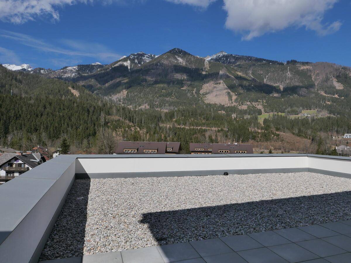 Dachterrasse mit Kiesbelag und beeindruckendem Panoramablick auf die Berge.
