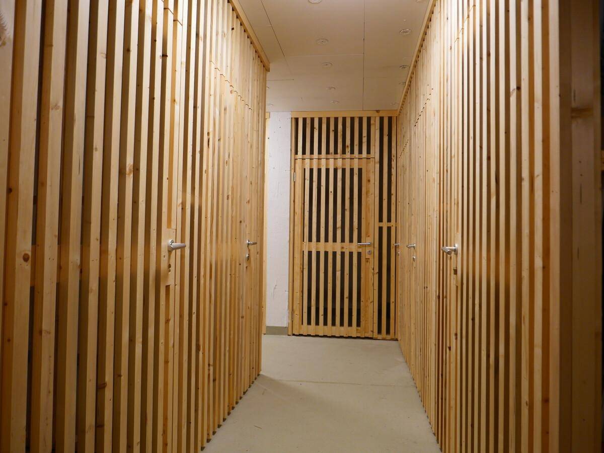 Kellerabteile mit Holzlattenwänden bieten praktischen Stauraum für Bewohner.