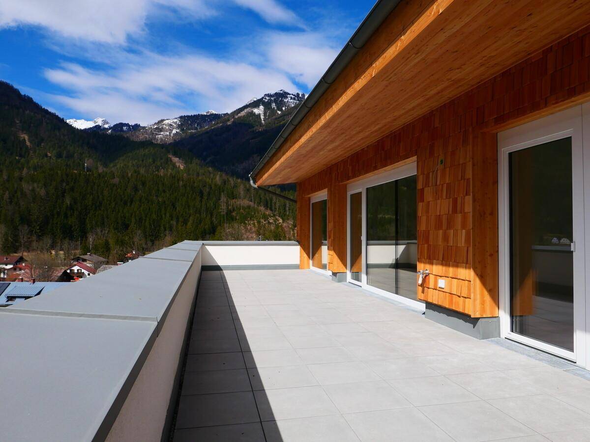 Große Terrasse mit Fliesenboden und weitem Blick auf die umliegende Berglandschaft.