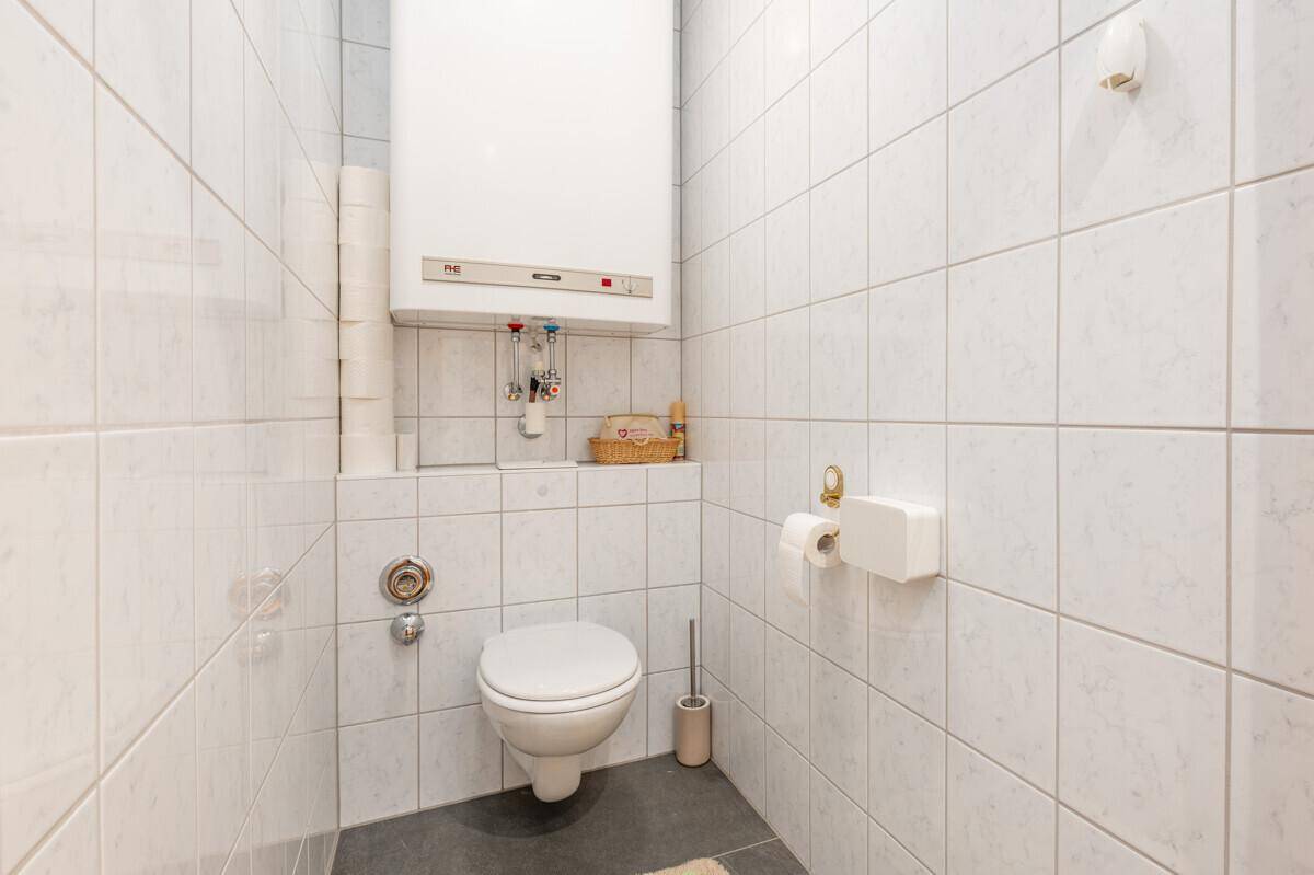 Separates WC mit Wand-WC und Fliesen, funktional und sauber.