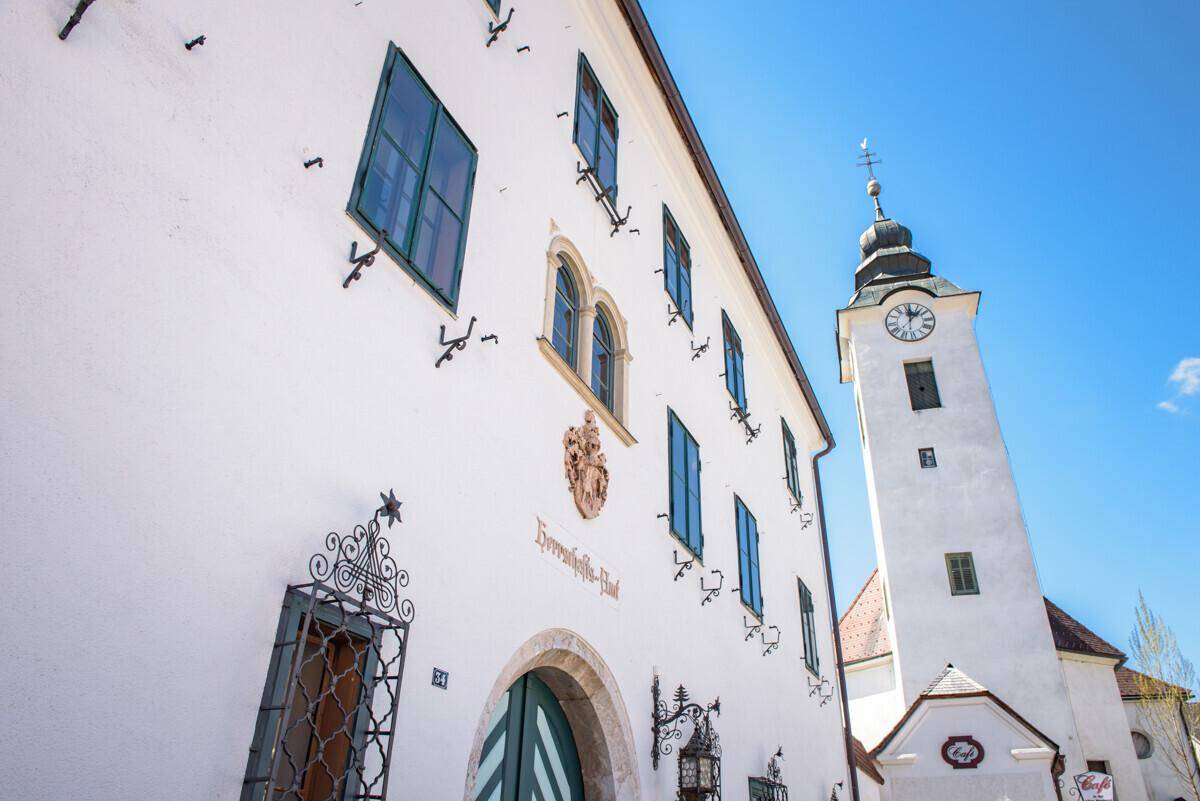 Historisches Gebäude mit Turm und traditioneller Architektur unter blauem Himmel.