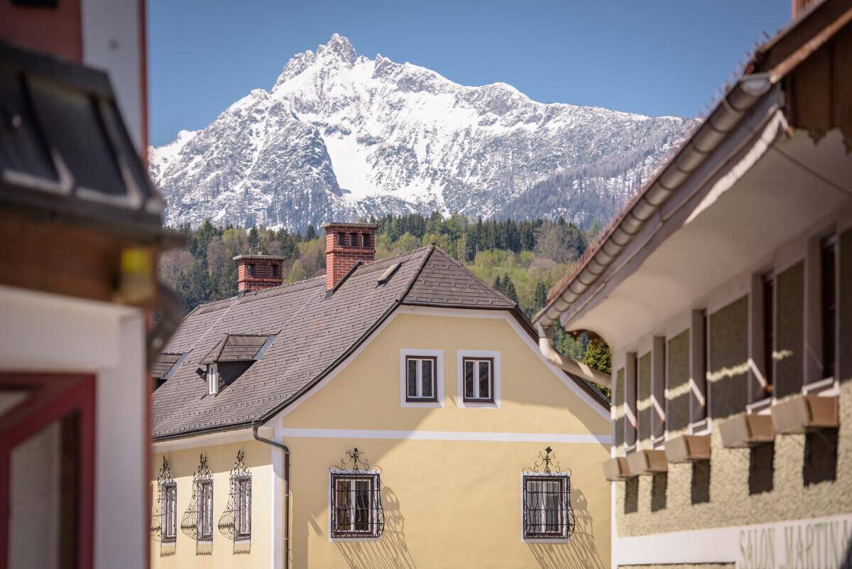 Traditionelles Haus mit Satteldach und Bergblick in einer malerischen Umgebung.