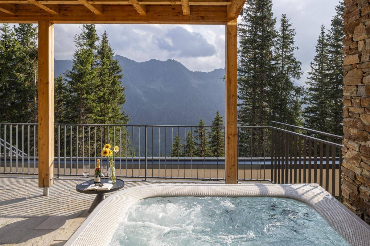 Große Terrasse mit Whirlpool und atemberaubendem Bergblick, ideal zum Entspannen im Freien.