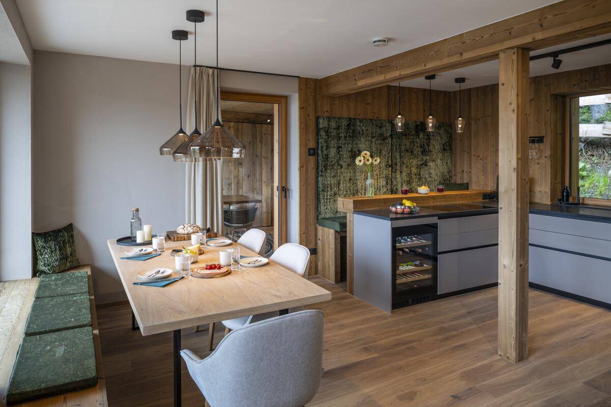 Offener Wohn-Essbereich mit moderner Küche, Holzelementen und einem gemütlichen Kamin.