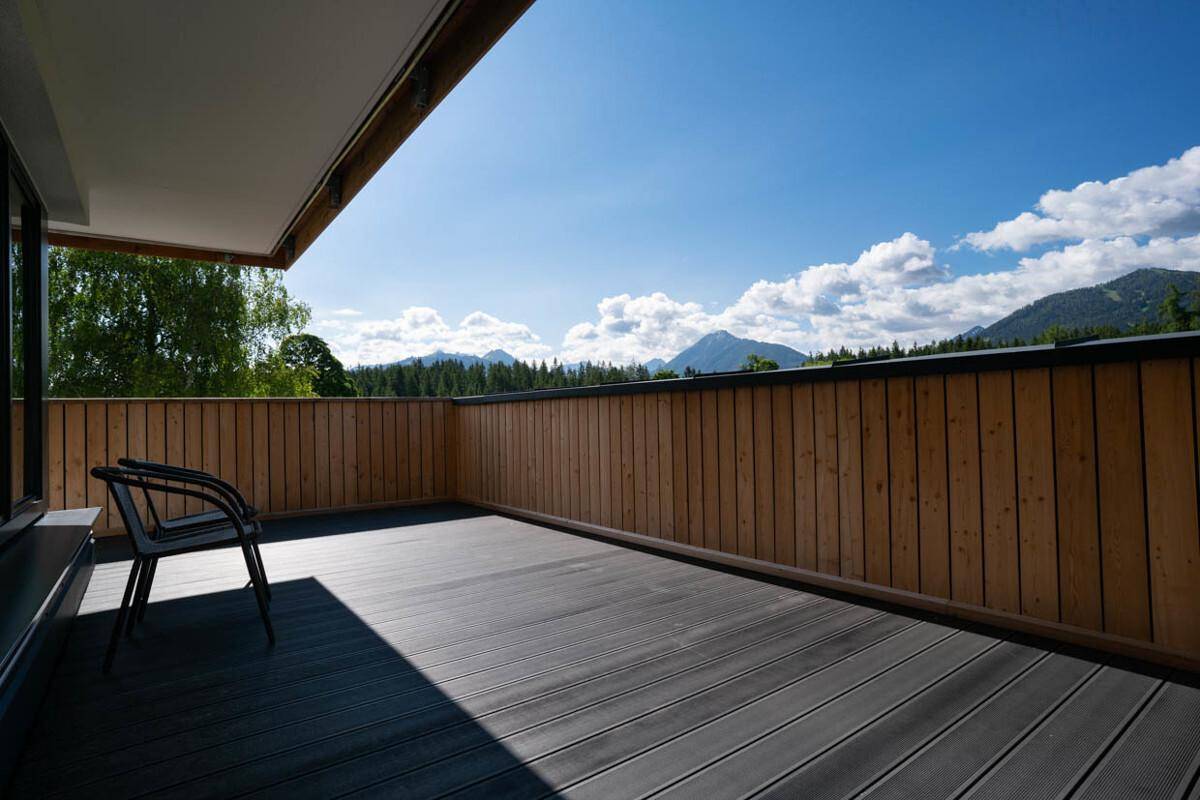 Große Terrasse mit Holzboden und atemberaubendem Panoramablick auf die Berge.