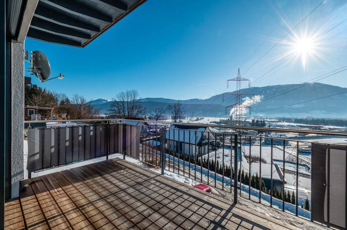Geräumiger Balkon mit Holzboden und weitreichendem Blick auf die umliegende Natur.