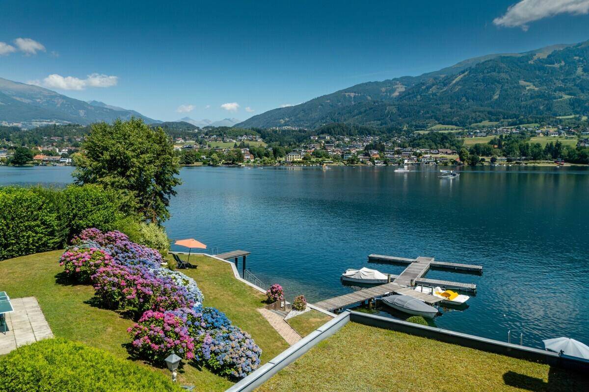 Panoramablick auf den See, den Garten mit Hortensien und die umliegende Landschaft.