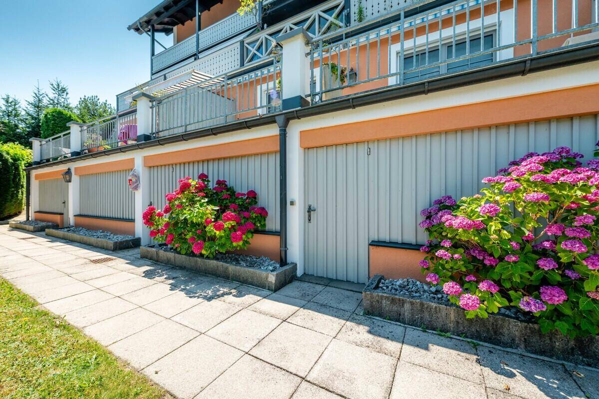 Reihe von Garagen am Gebäude, umgeben von gepflegten Blumenbeeten.