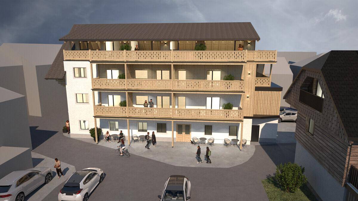 Ansicht des neuen Gebäudes mit Holzfassade, Balkonen und Außenbereich.