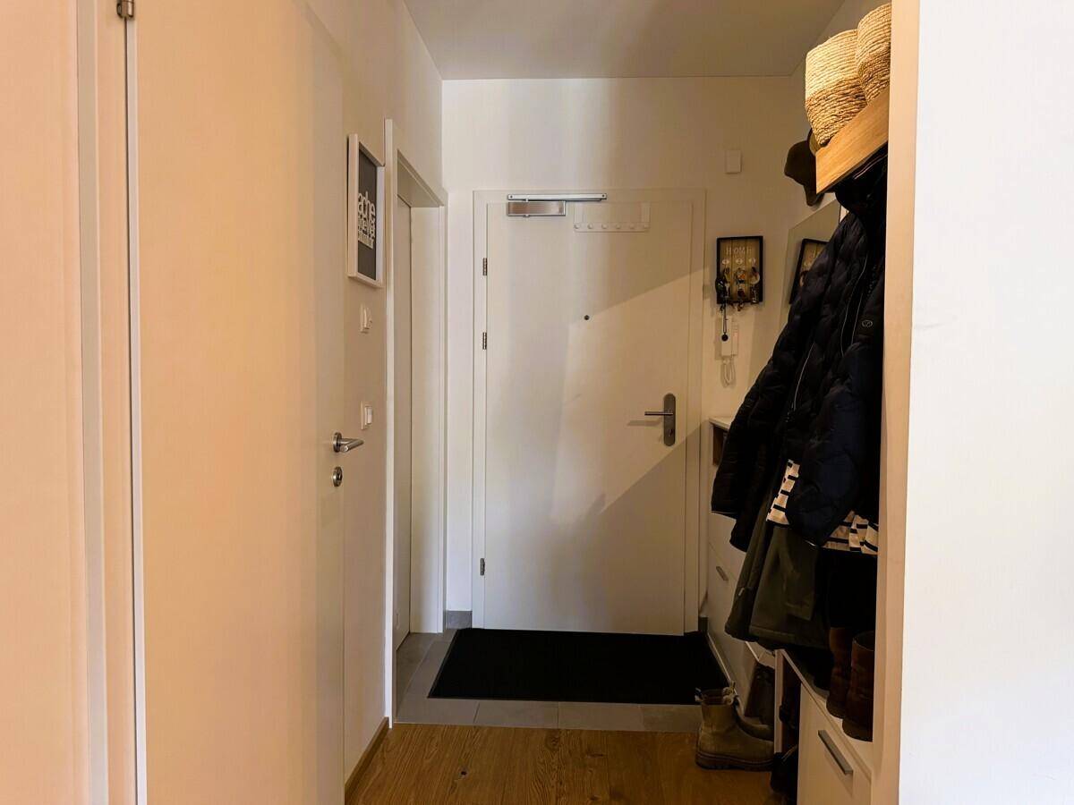 Heller Eingangsbereich mit Garderobe und modernem Holzboden.