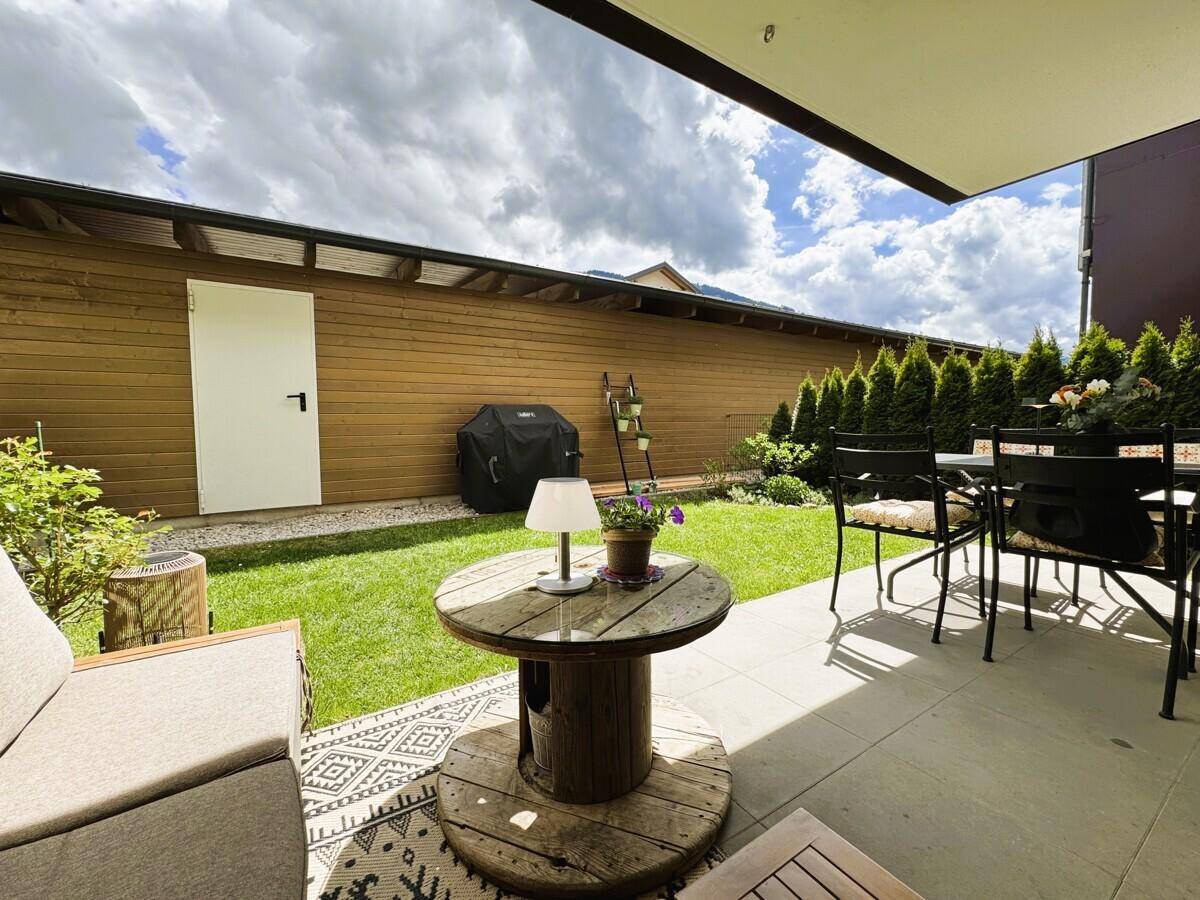 Gepflegter Gartenbereich mit Terrasse, Grillplatz und Blick auf die umliegende Landschaft.