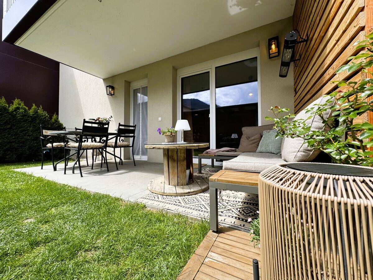 Einladende Terrasse mit verschiedenen Sitzbereichen und direktem Zugang zum Garten.