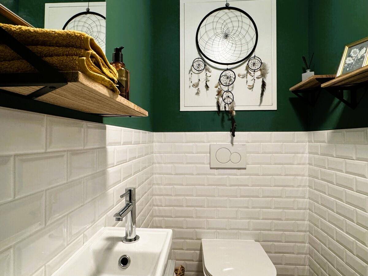 Modernes Gäste-WC mit weißen Metrofliesen, grün gestrichenen Wänden und Wand-WC.