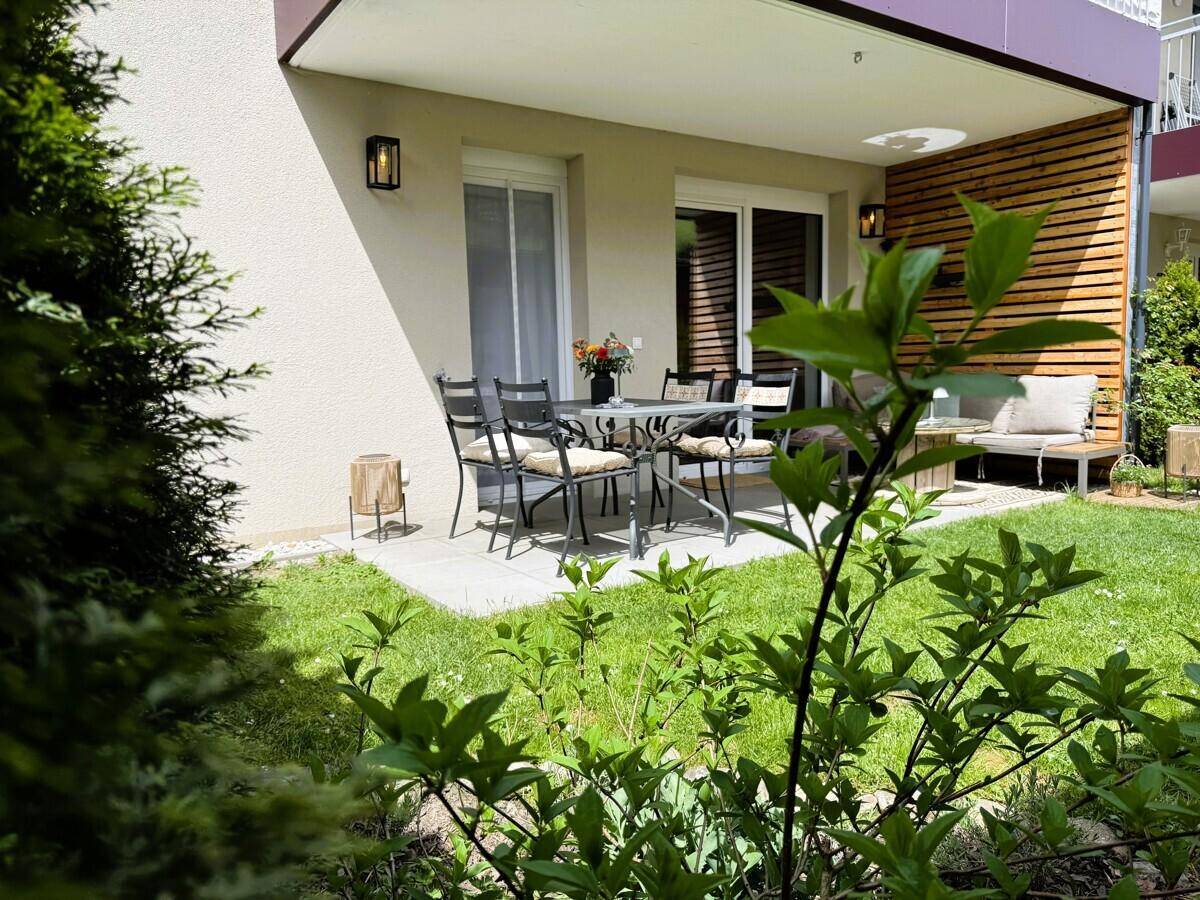 Grüne Gartenterrasse mit Sitzgelegenheiten und Blick auf die umliegende Natur.