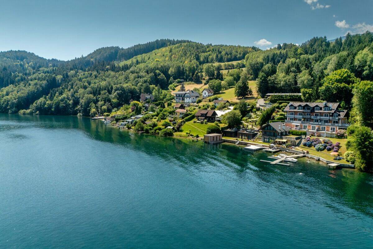 Panoramablick über den weiten See und die bewaldeten Berge in der Ferne.