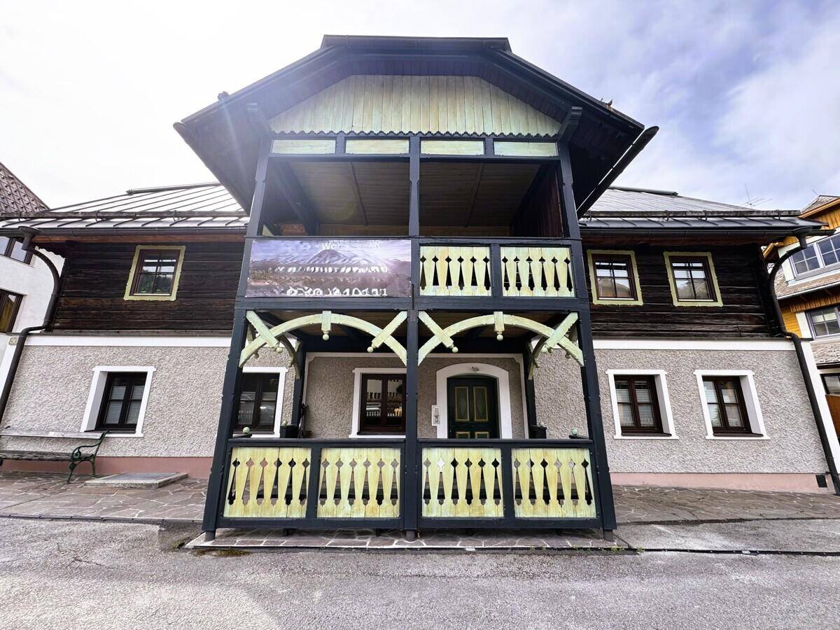 Vorderansicht eines charmanten traditionellen Hauses mit aufwendig gestalteten Holzbalkonen.