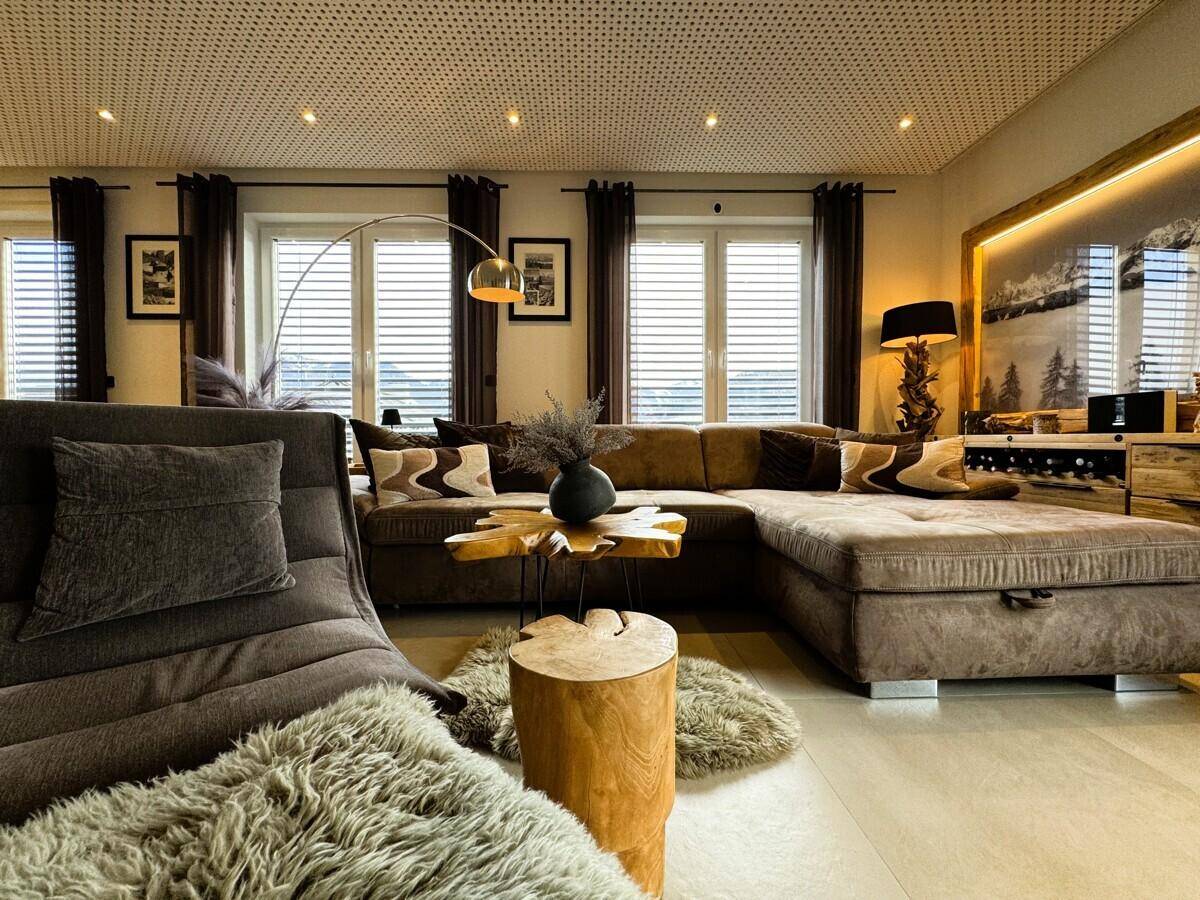 Heller Wohnbereich mit bequemer Couch, Holztischen und stilvoller Einrichtung.