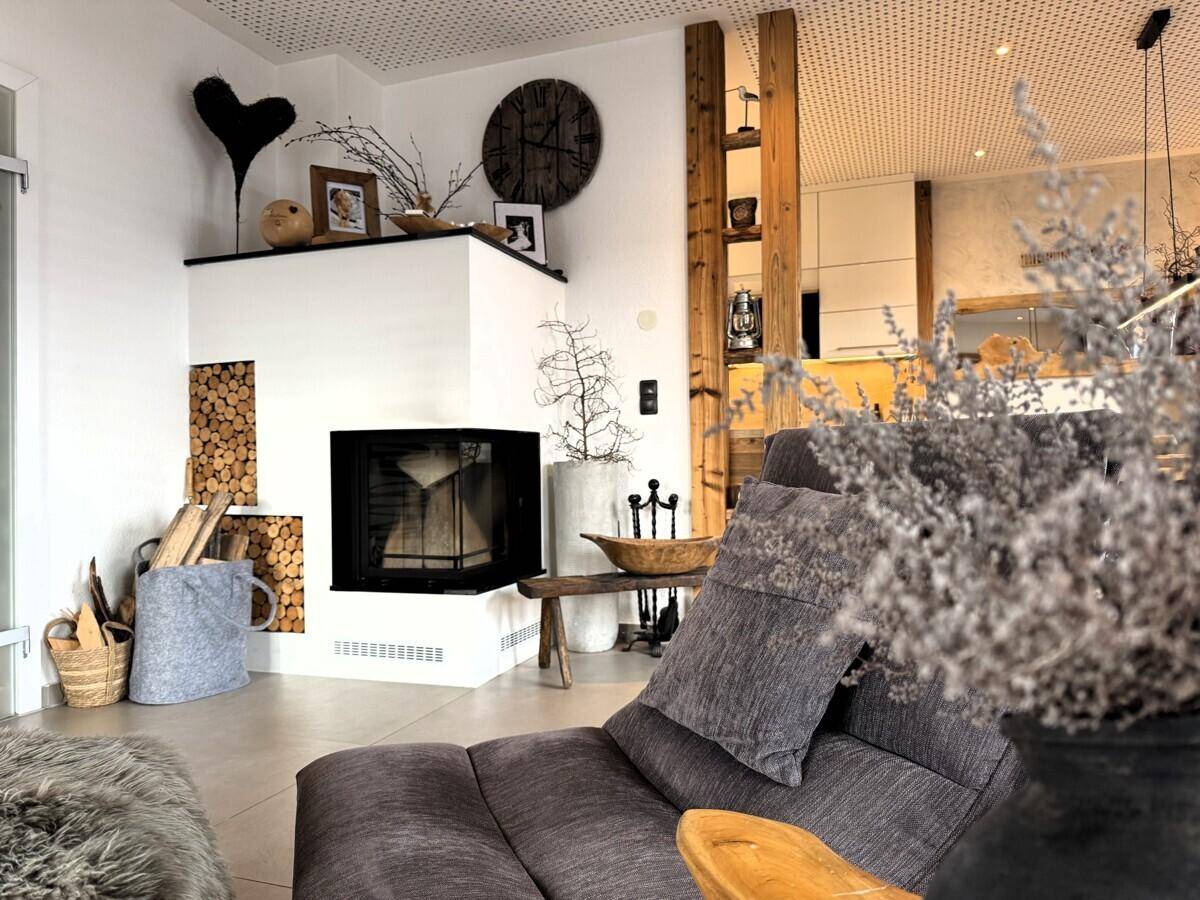 Rustikales Wohnzimmer mit modernem Kamin, Holzelementen und gemütlicher Atmosphäre.