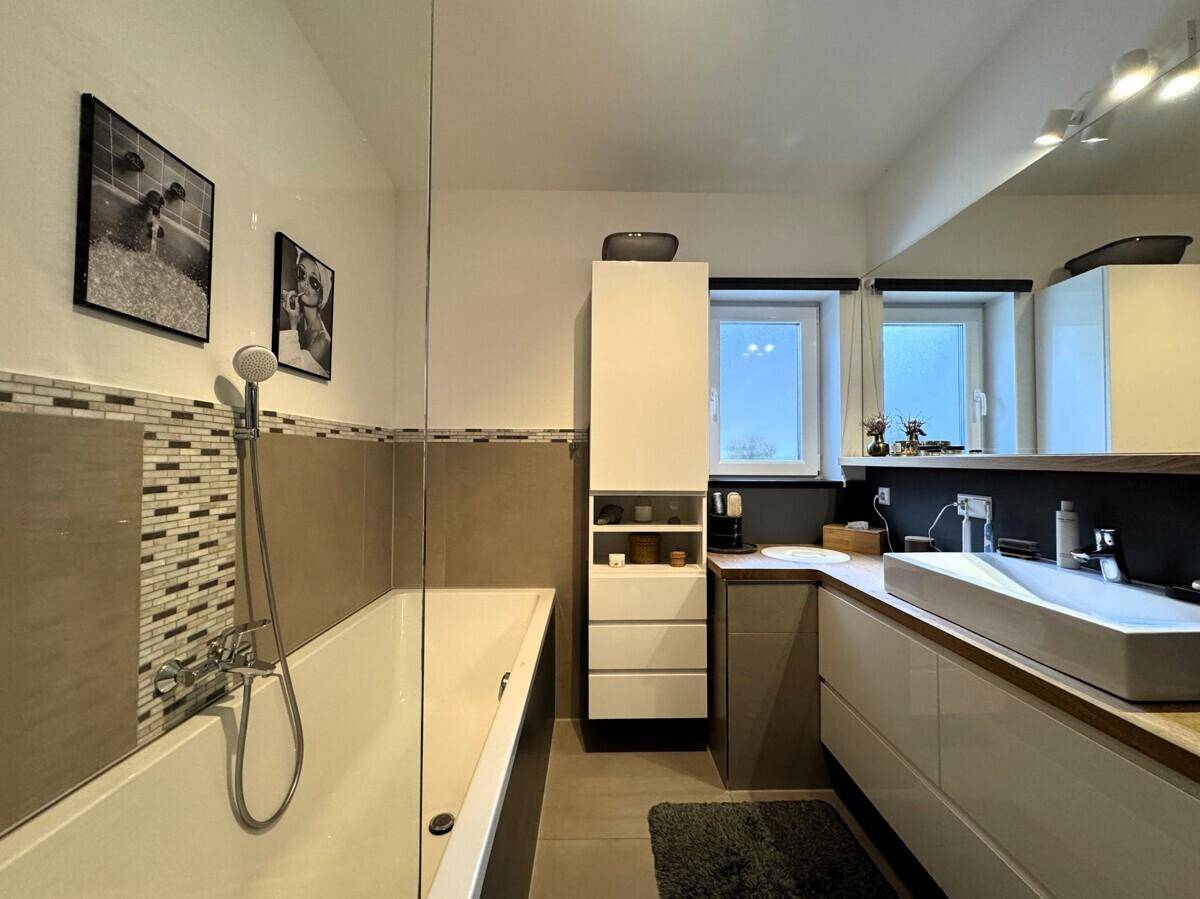 Modernes Badezimmer mit Badewanne, Dusche und Doppelwaschbecken.