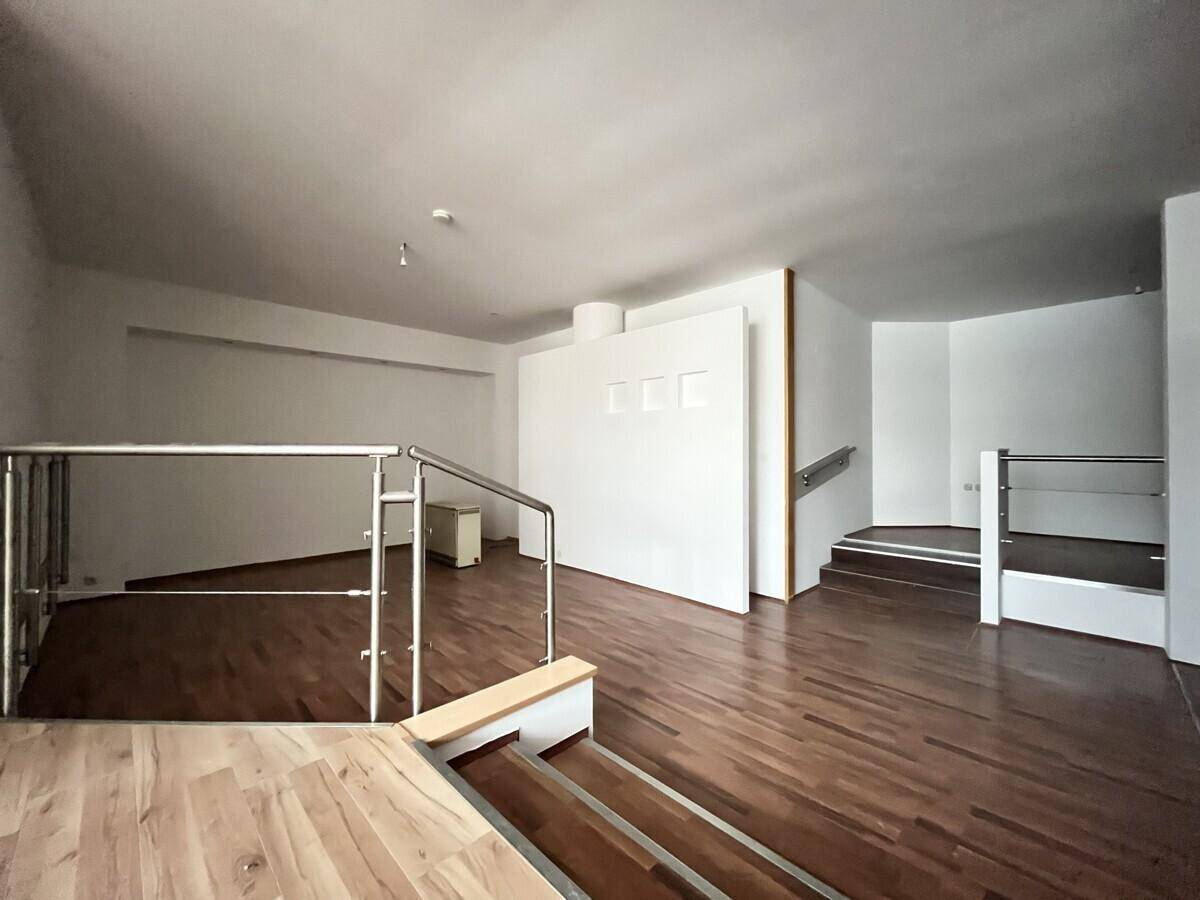Geräumiger Wohnbereich mit Holzfußboden und offener Gestaltung über mehrere Ebenen.