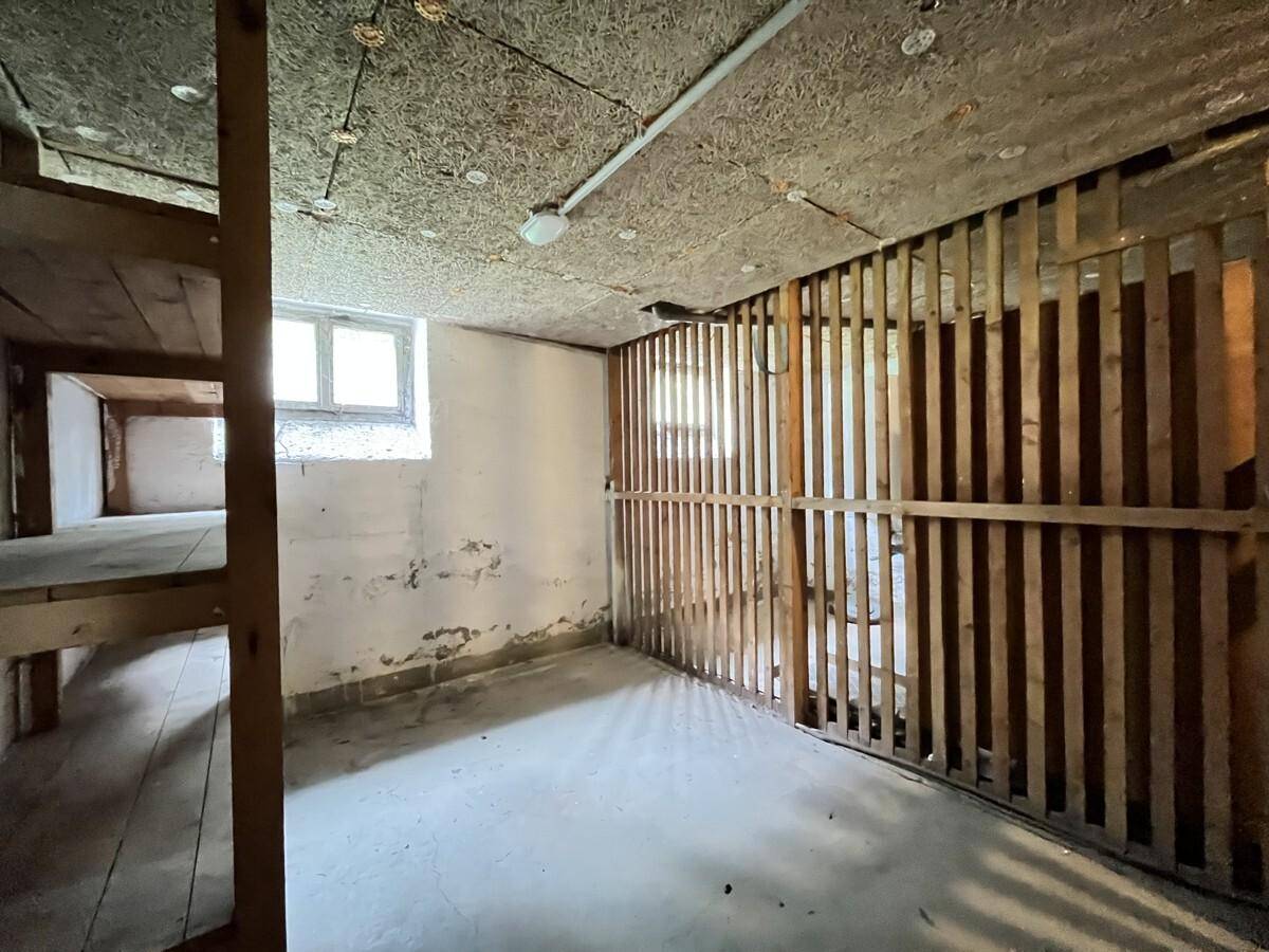 Unausgebauter Kellerraum mit Holzbalken und Betonboden, bietet viel Stauraum.