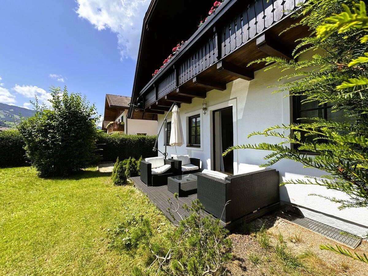 Seitenansicht des Hauses mit Terrasse, Garten und Blick auf die Umgebung.