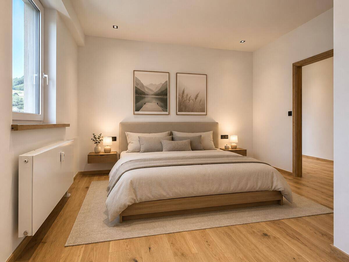 Gemütliches Schlafzimmer mit Holzboden, großem Bett und natürlichem Lichteinfall.