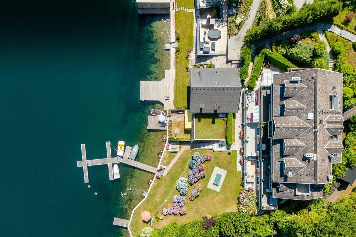 Draufsicht auf das Grundstück mit Seezugang, Garten und Bootsanlegestellen.