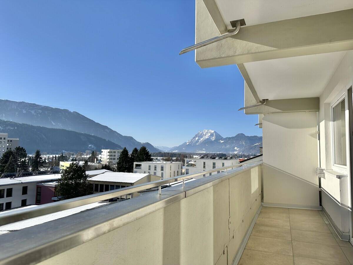 Geräumiger Balkon mit Fliesenboden und weitem Blick auf die umliegende Berglandschaft.