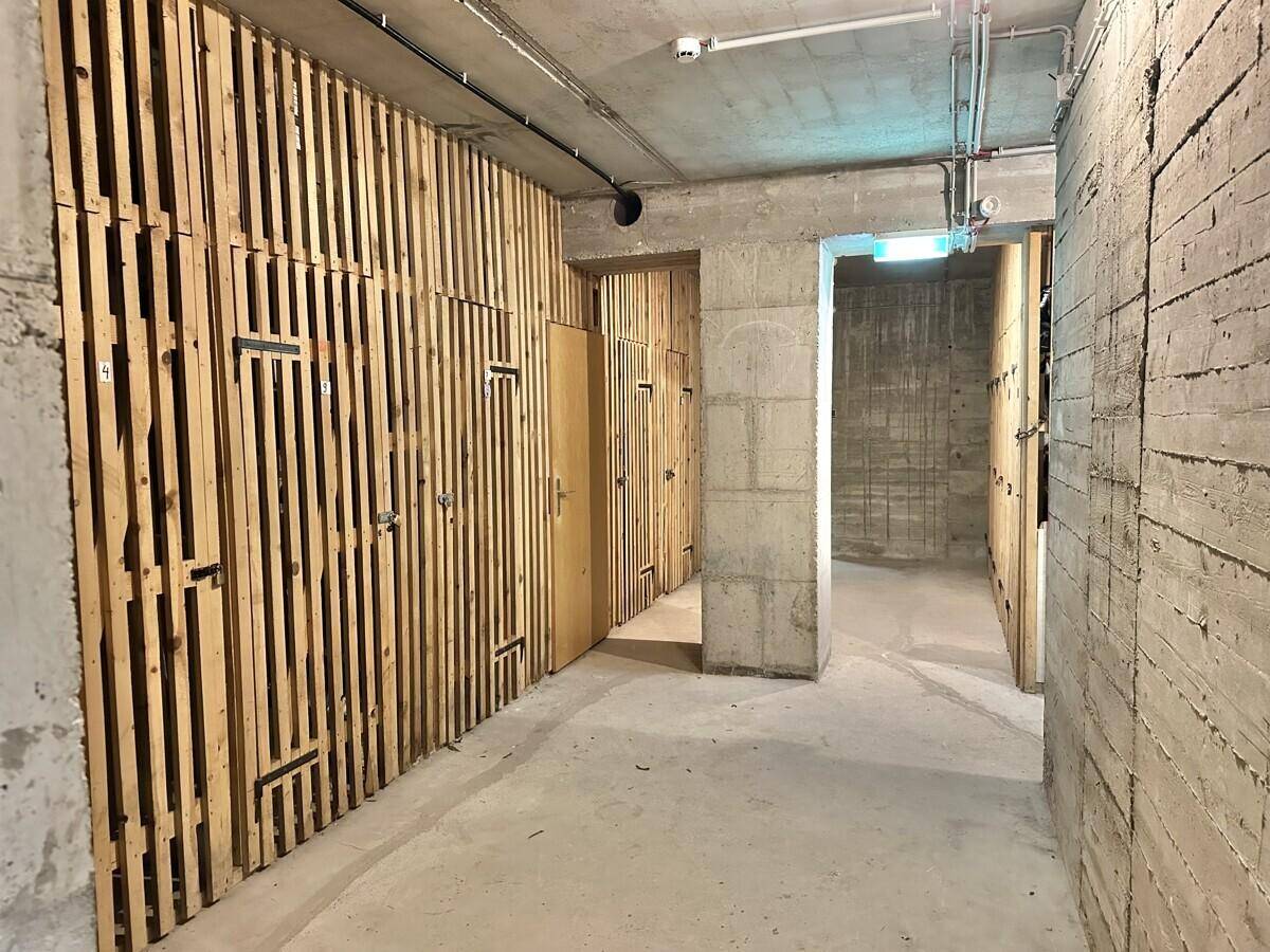 Kellerabteil mit individuellen Lagereinheiten aus Holzlatten und Betonboden.
