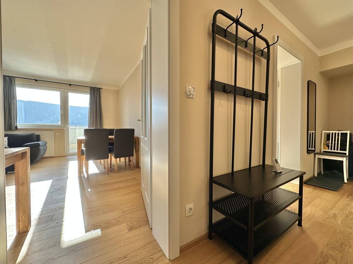 Heller Eingangsbereich mit Garderobe und offenem Zugang zum Wohn-Essbereich.