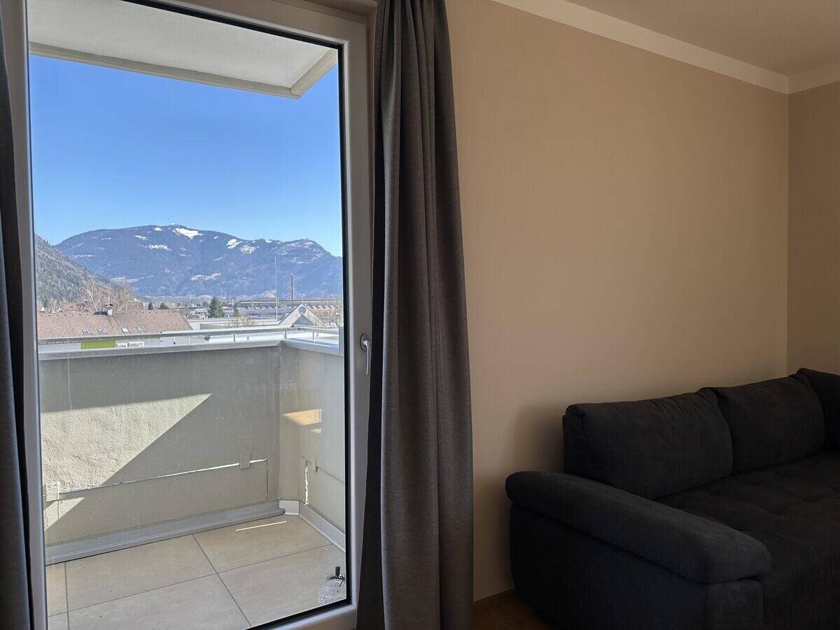 Blick vom Wohnzimmer auf den Balkon und die beeindruckende Berglandschaft.