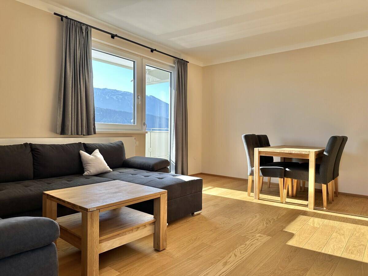Offener Wohn-Essbereich mit Sofa, Esstisch und Holzboden.